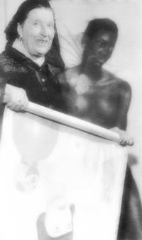 Hedwig Woermann mit einem Rollbild und im Hintergrund das Bild    · Wolf Karge, Hedwig Woermann 1879-1960, Katalog; herausgegeben vom Landkreis Vorpommern-Rügen, Ribnitz-Damgarten 1996